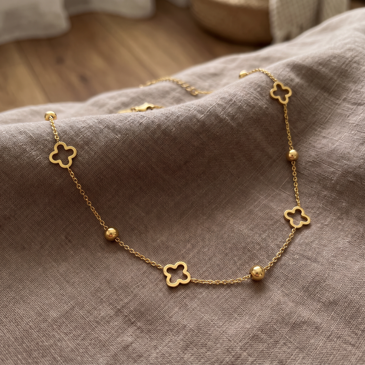 Collier ras de cou trèfle à motif ajouré, porté en tenue, doré