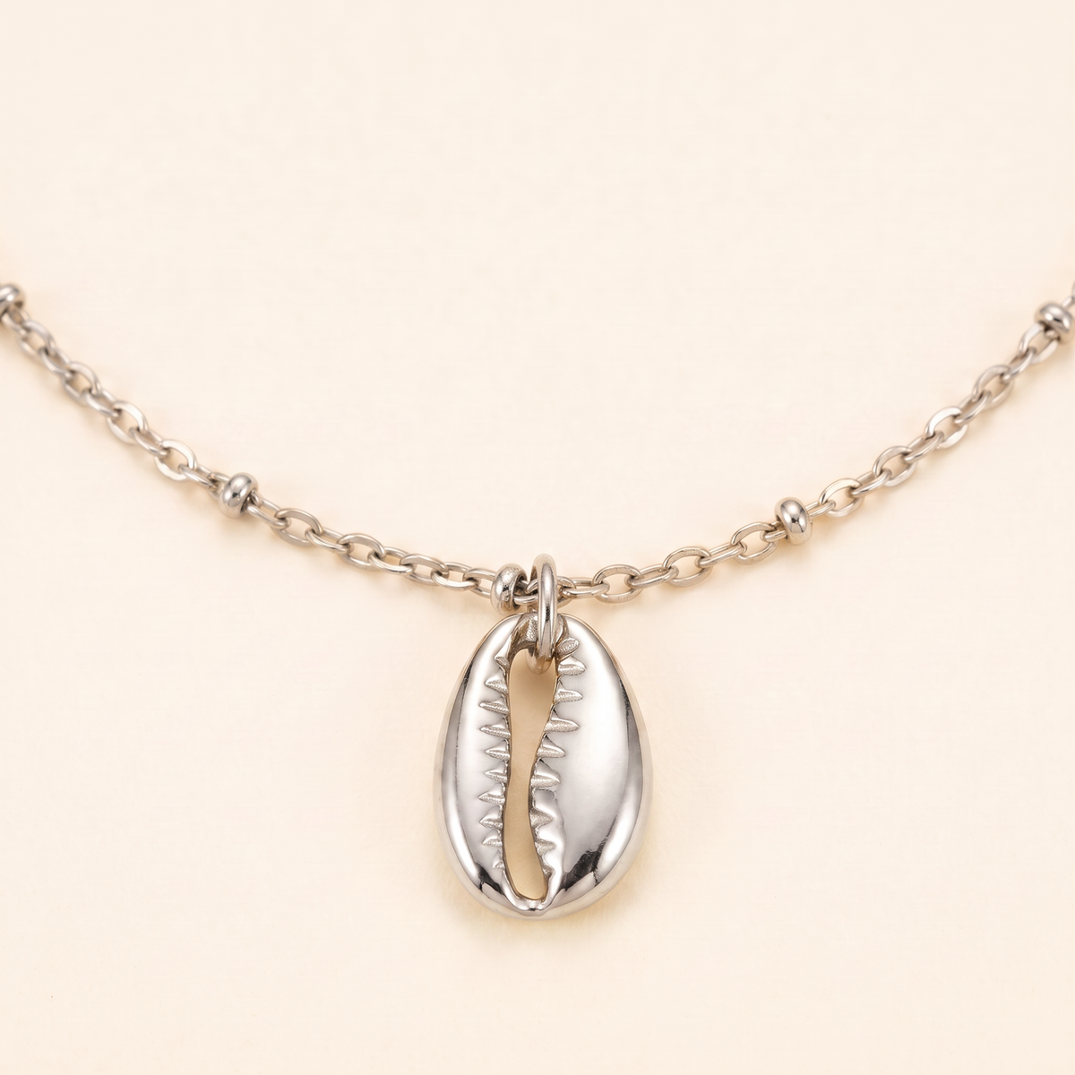 Collier cauri minimaliste, détail du motif, argenté