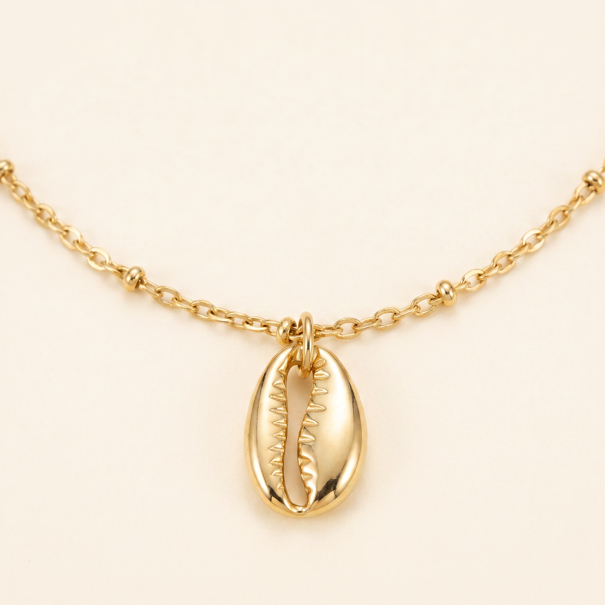 Collier cauri minimaliste, détail du motif, doré