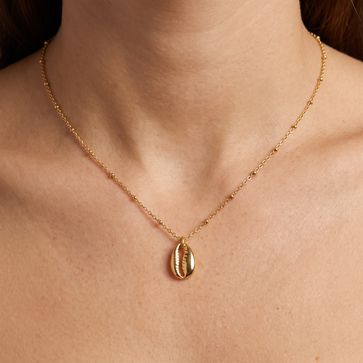 Collier cauri minimaliste, porté, doré