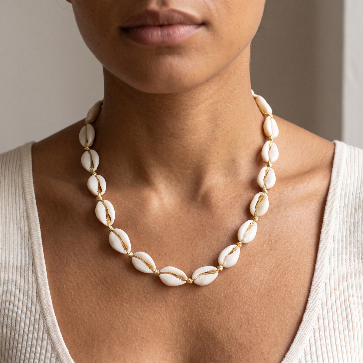 Collier ras de cou coquillage doré, porté mi-corps