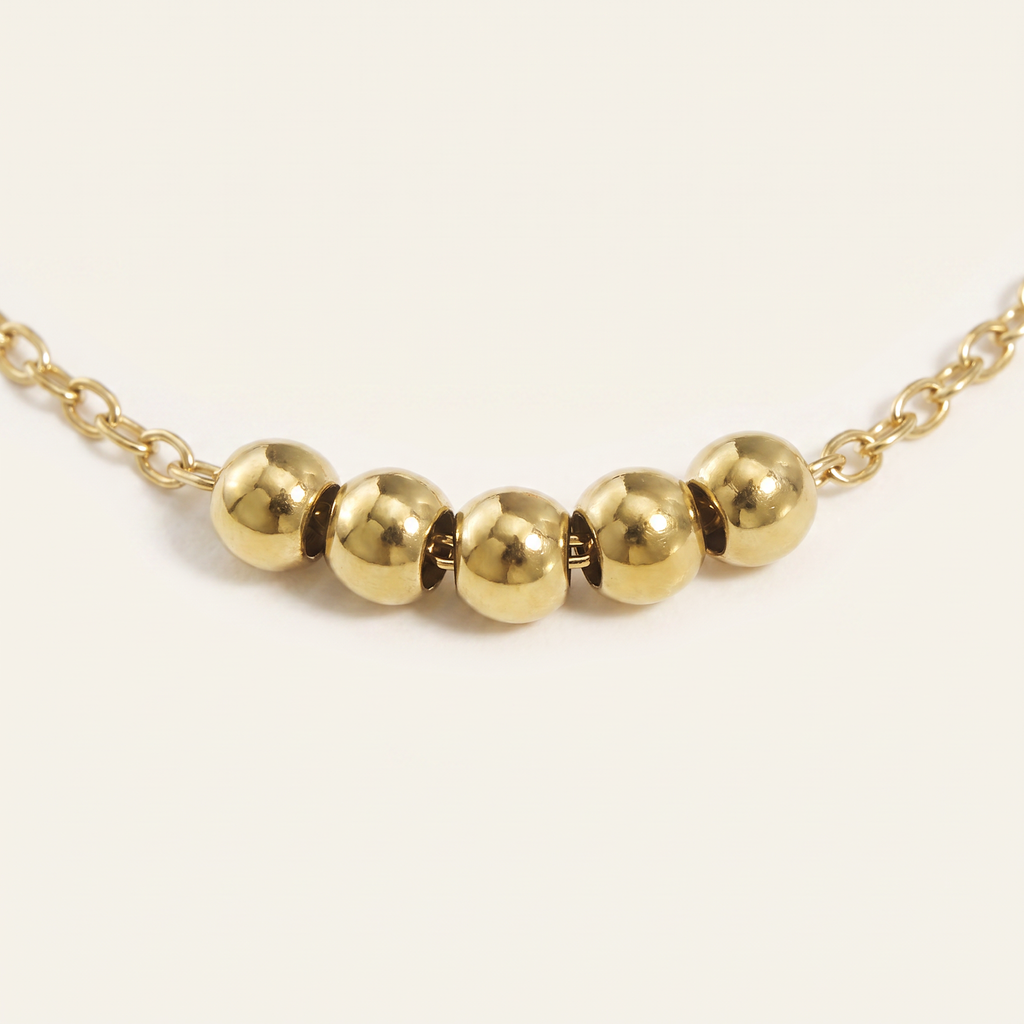 Collier ras de cou à boules, détail du motif, doré