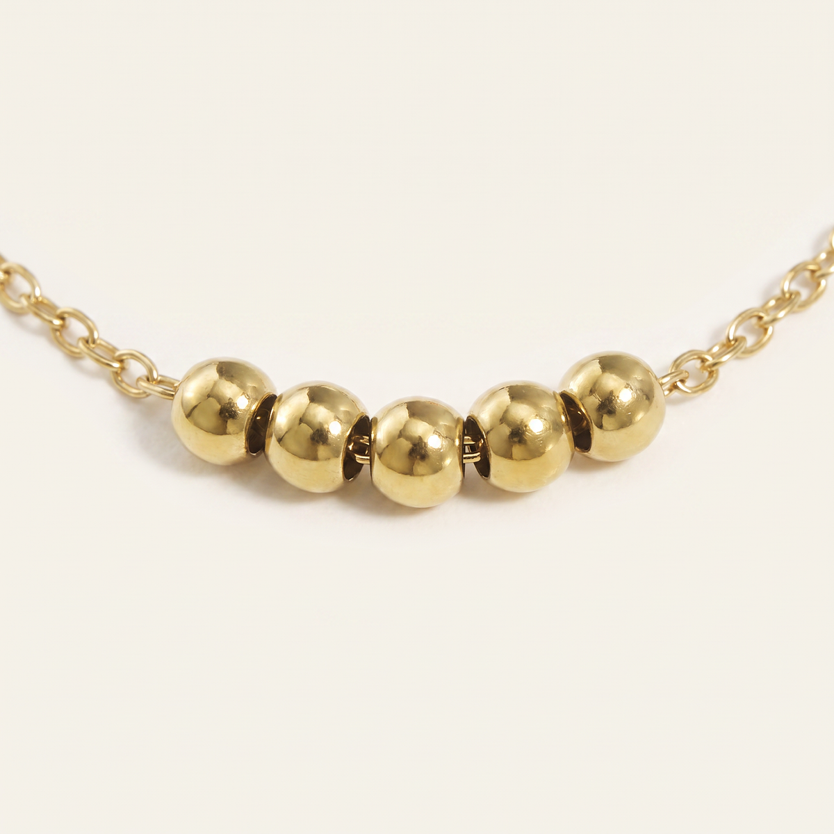 Collier ras de cou à boules, détail du motif, doré