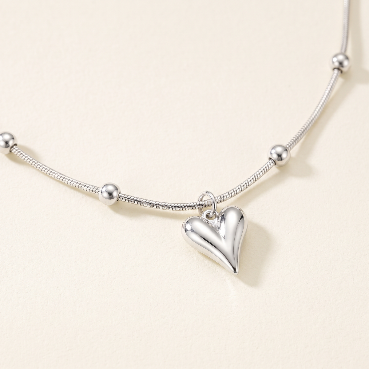 Collier cœur sur chaîne à boules, détail du motif, argenté