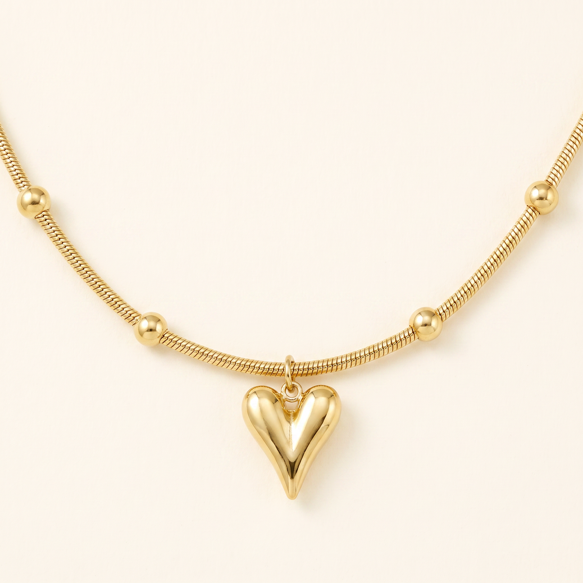 Collier cœur sur chaîne à boules, détail du motif, doré