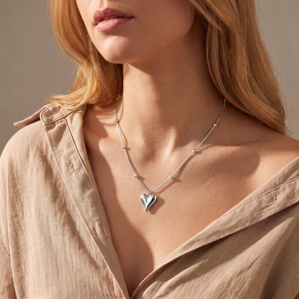 Collier cœur sur chaîne à boules, porté mi-corps, argenté