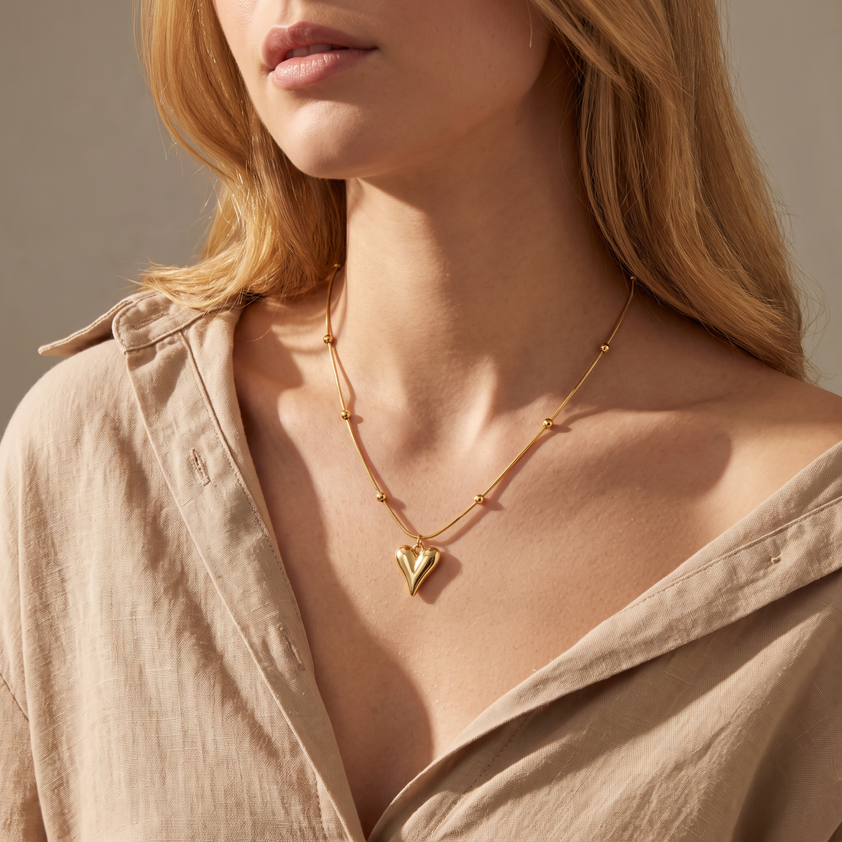 Collier cœur sur chaîne à boules, porté mi-corps, doré