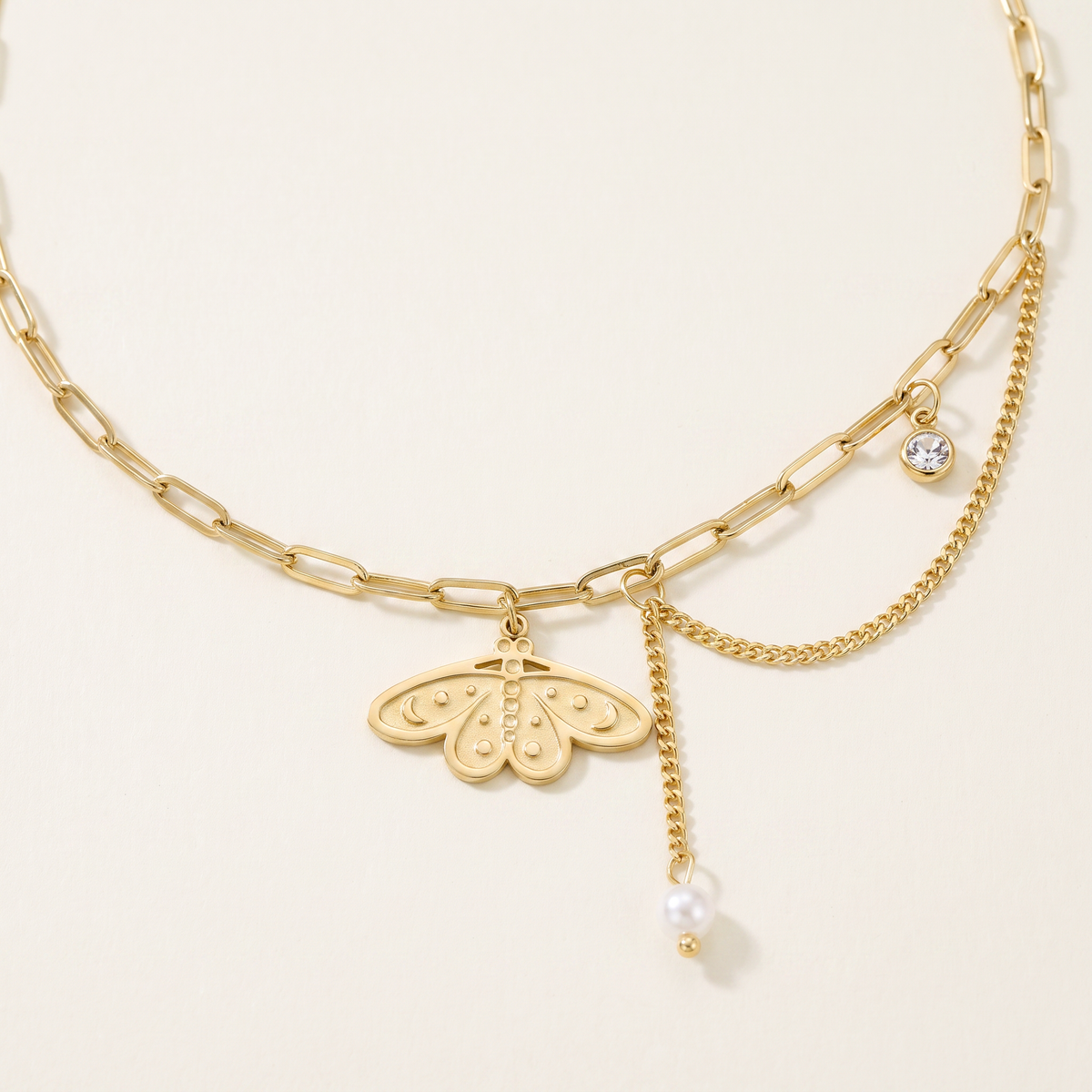 Collier ras de cou papillon à breloques, détail du motif, doré