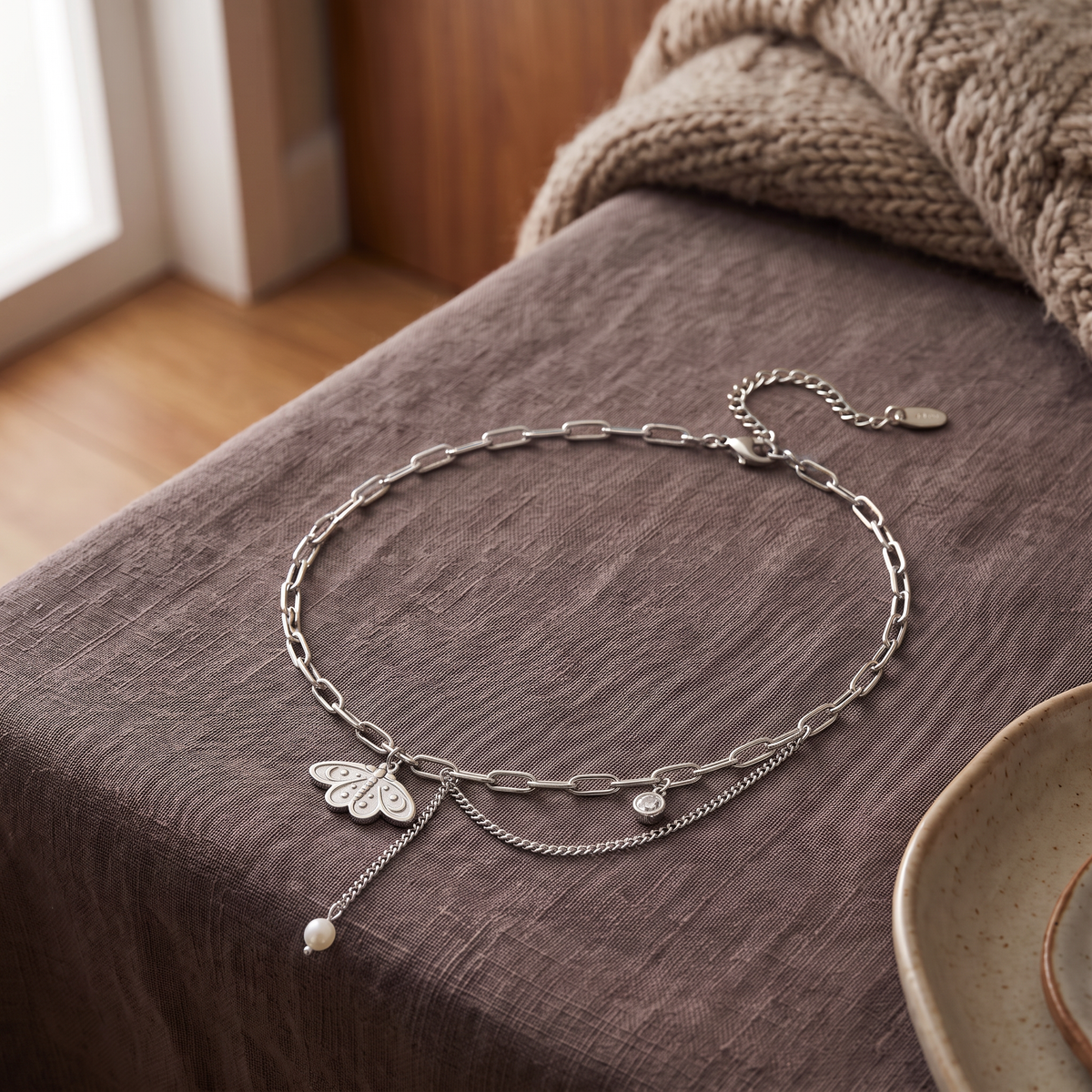 Collier ras de cou papillon à breloques, porté en tenue, argenté