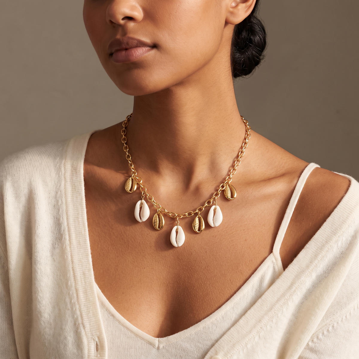 Collier coquillage blanc sur chaîne, porté mi-corps, doré