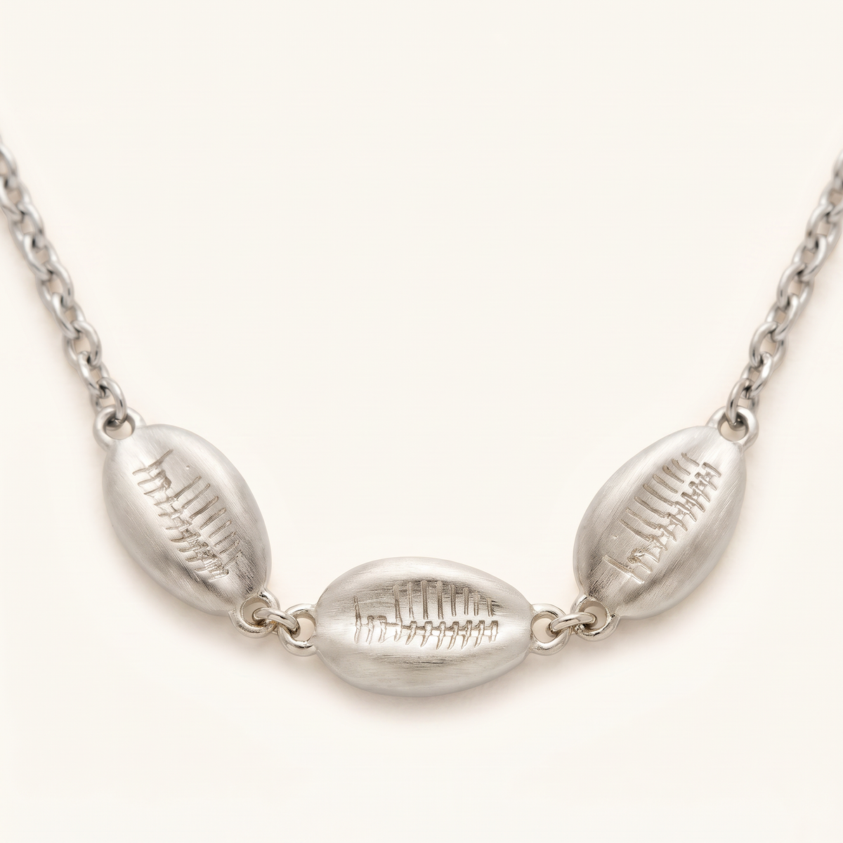 Collier cauri sur chaîne, détail du motif, argenté