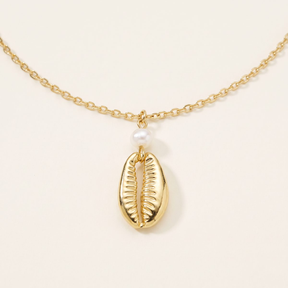 Collier cauri en perles, détail du motif, doré