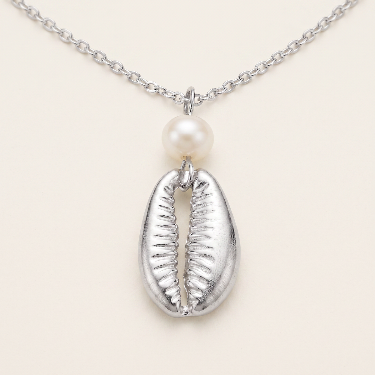 Collier cauri en perles, détail du motif, argenté