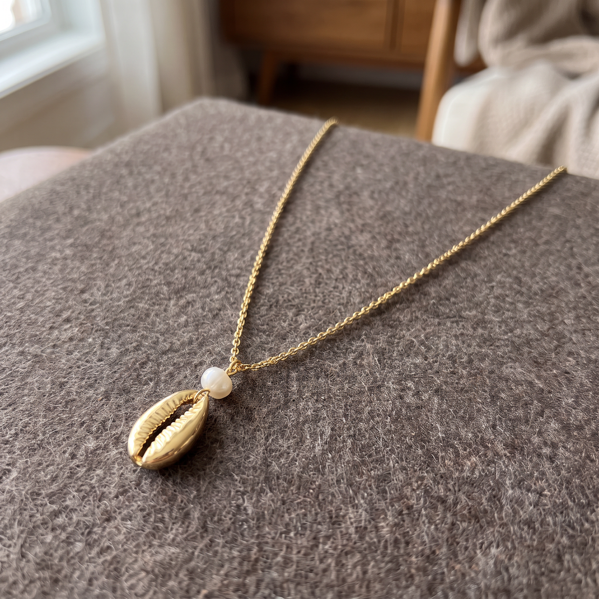 Collier cauri en perles, porté en tenue, doré