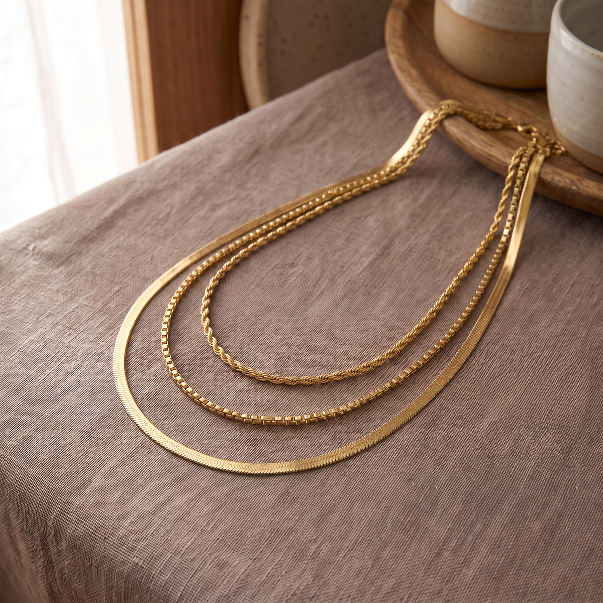 Collier à finition texturée triple rang, porté en tenue, doré