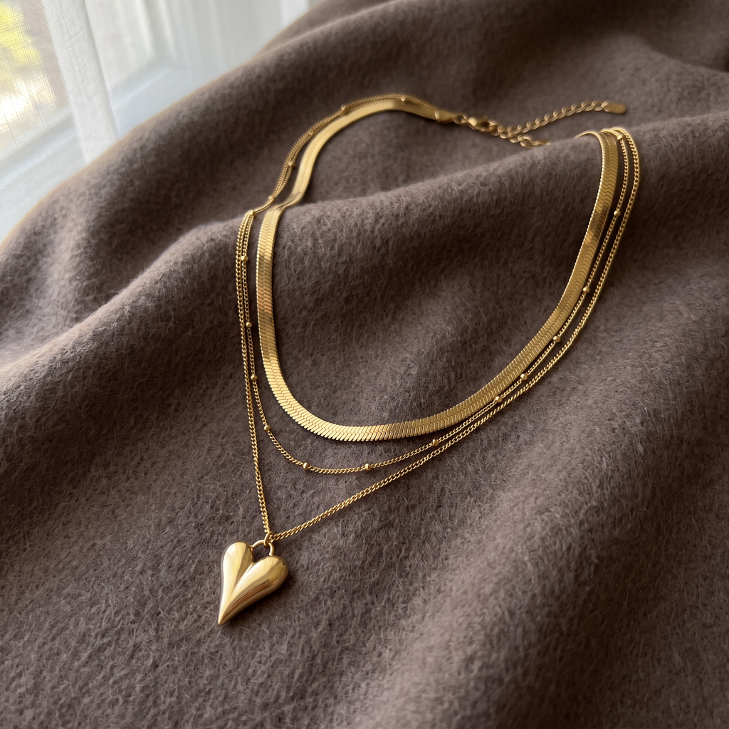 Collier cœur doré triple rang, porté en tenue