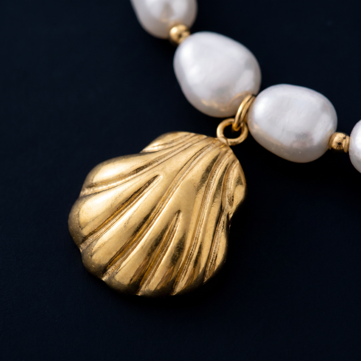 Collier ras de cou coquillage doré à breloques, motif en gros plan