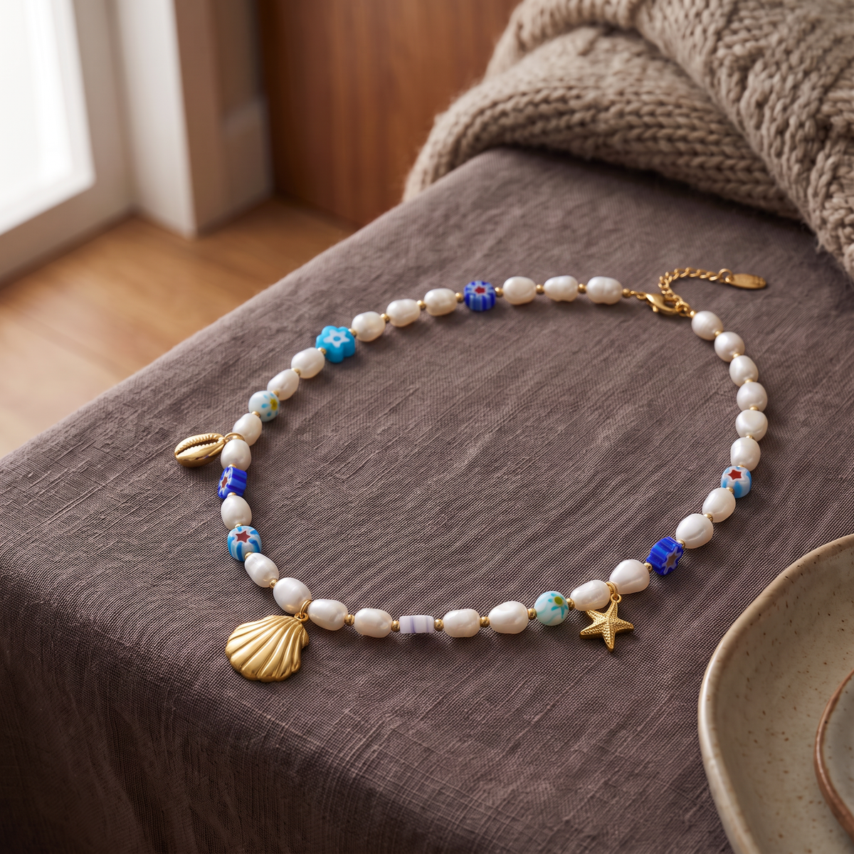 Collier ras de cou coquillage doré à breloques, porté en tenue