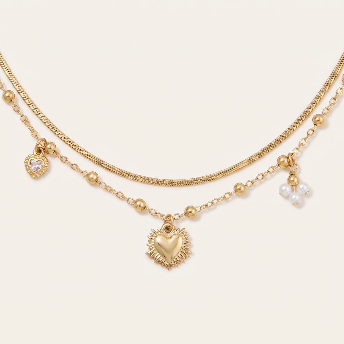 Collier cœur et breloques double rang, détail du motif, doré
