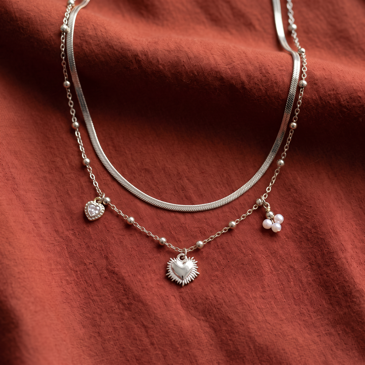 Collier cœur et breloques double rang, porté en tenue, argenté