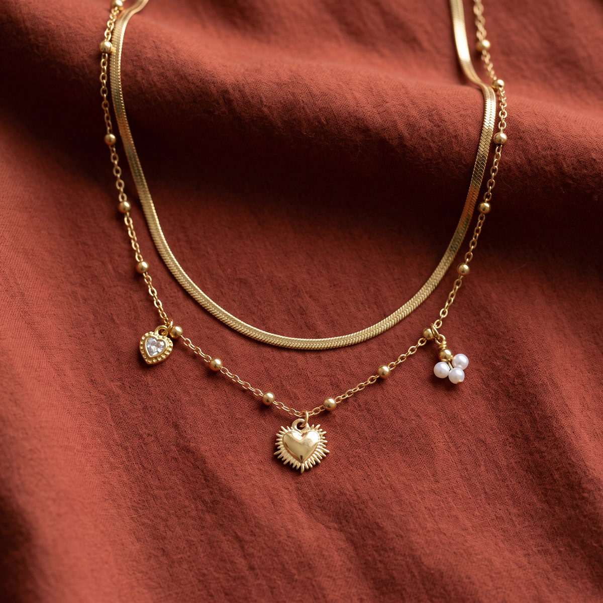 Collier cœur et breloques double rang, porté en tenue, doré