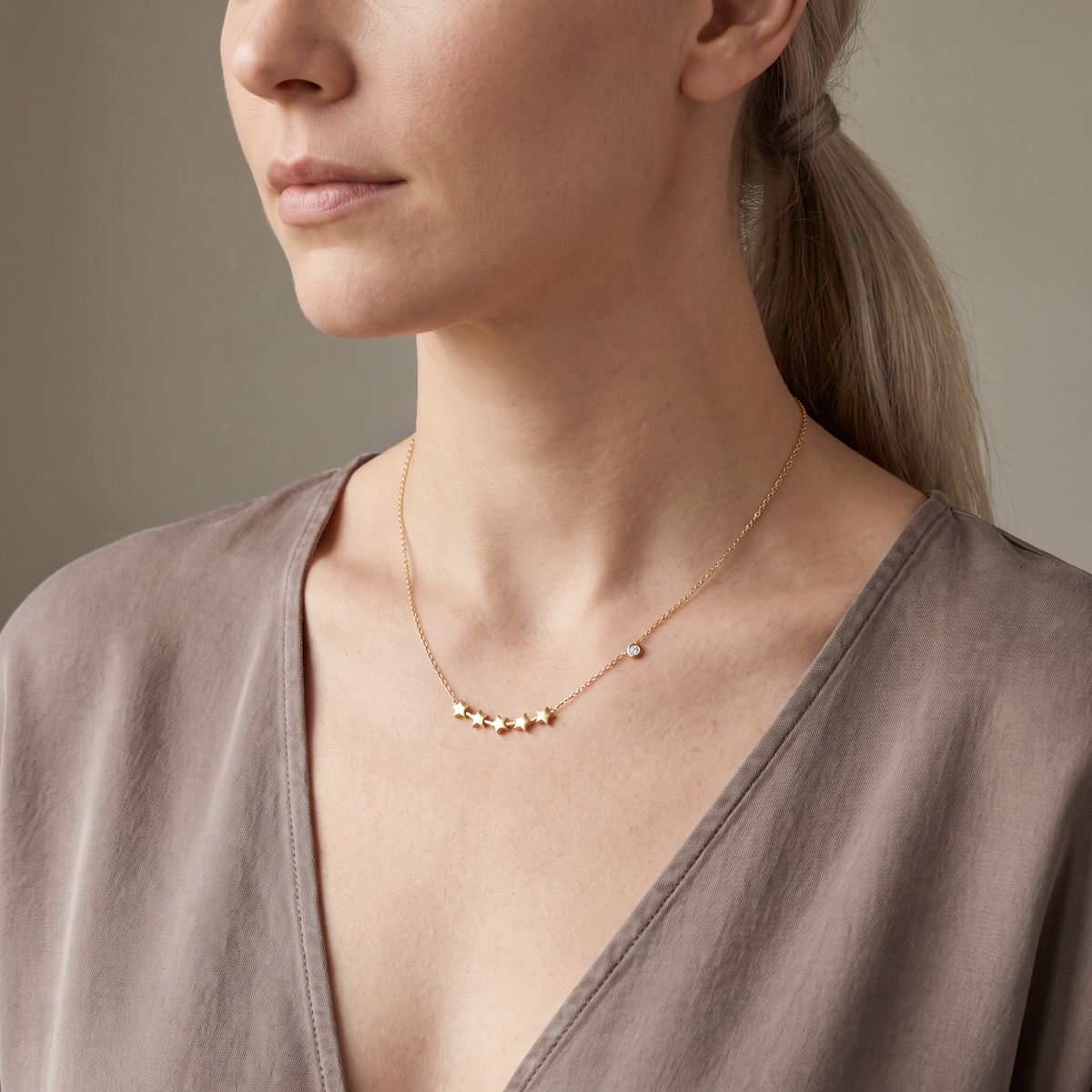 Collier étoile à motif constellation sur chaîne, porté mi-corps, doré