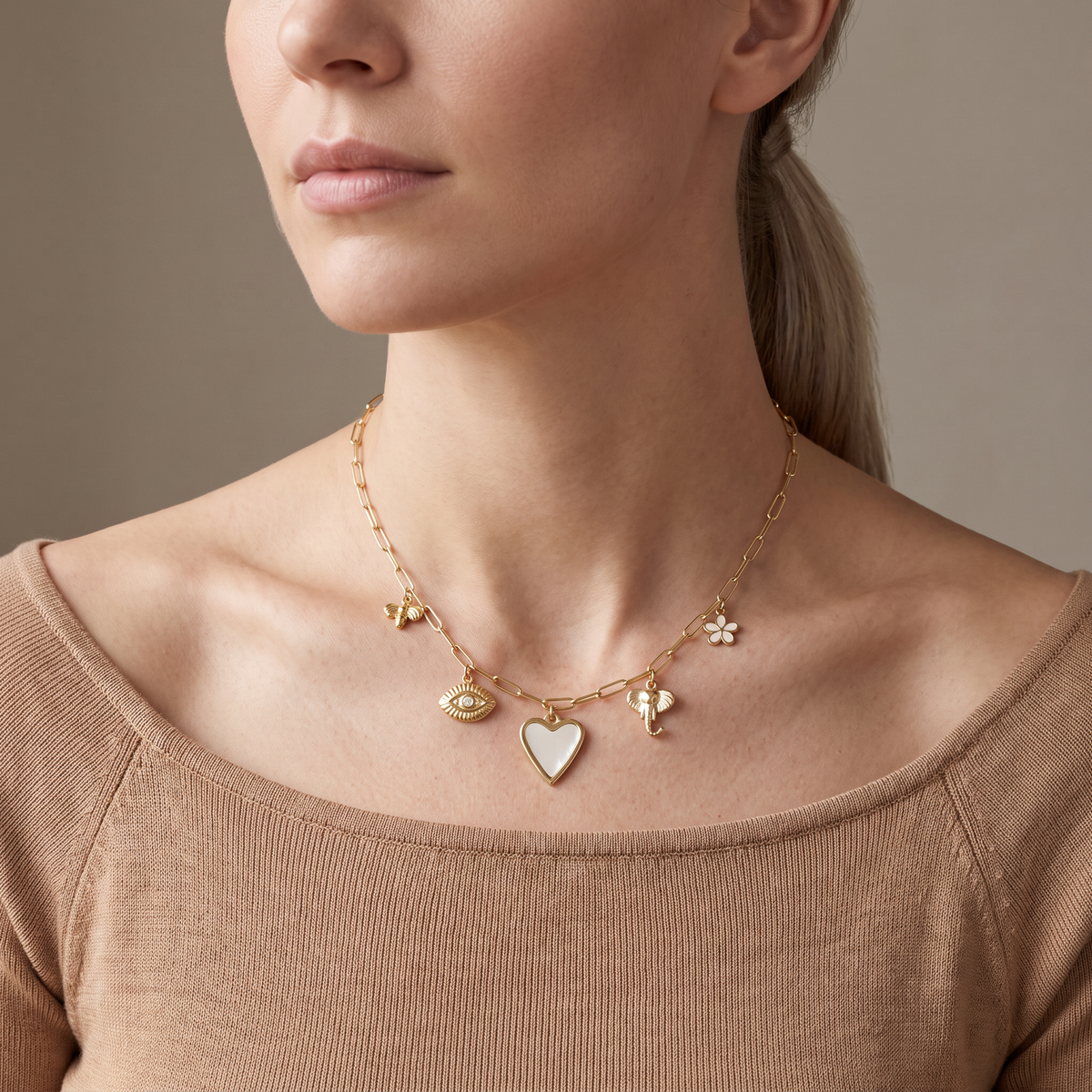 Collier charms cœur, œil et éléphant, porté mi-corps, doré
