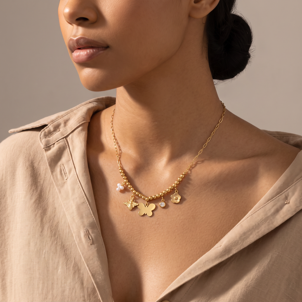 Collier charms fleur et papillon, porté mi-corps, doré