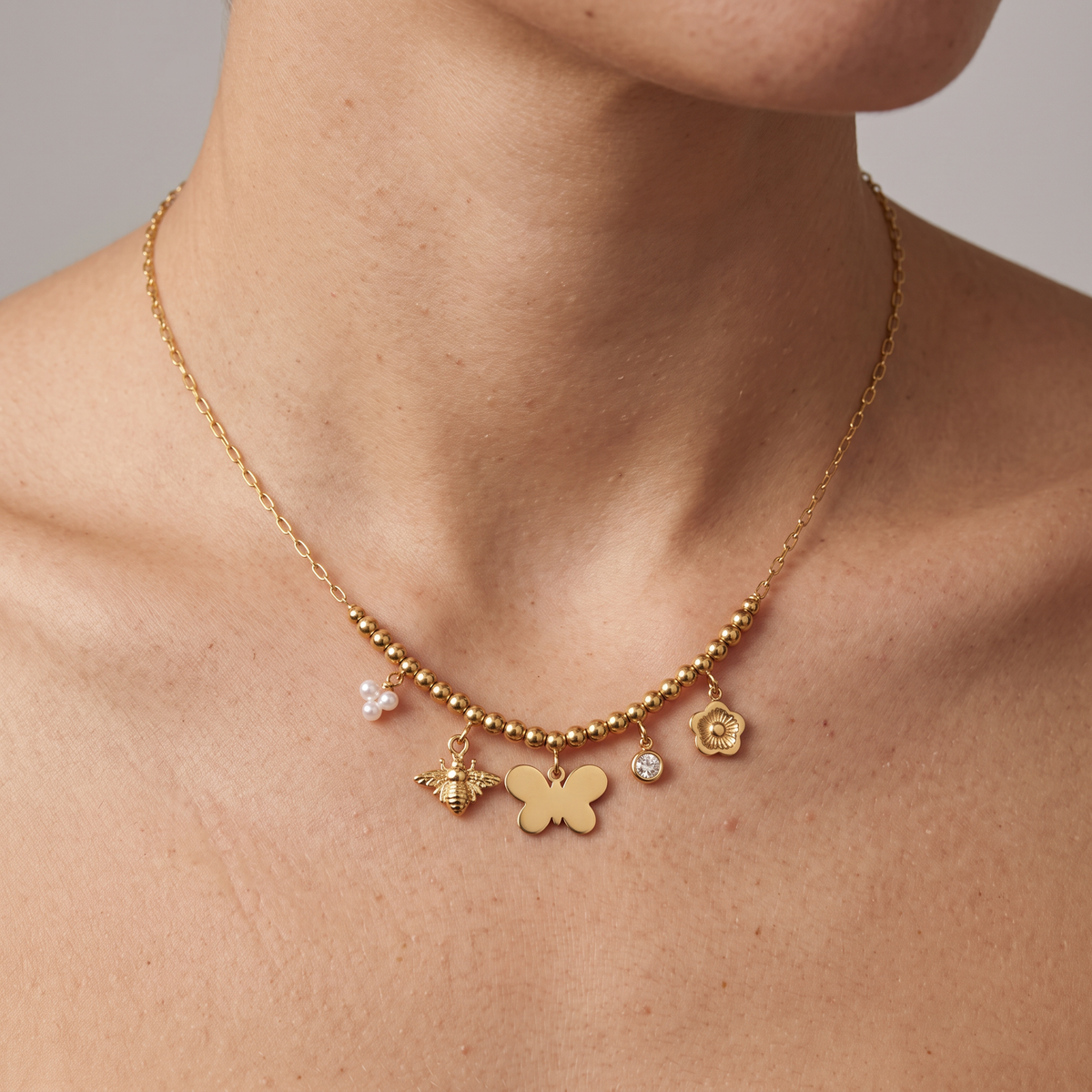 Collier charms fleur et papillon, porté, doré