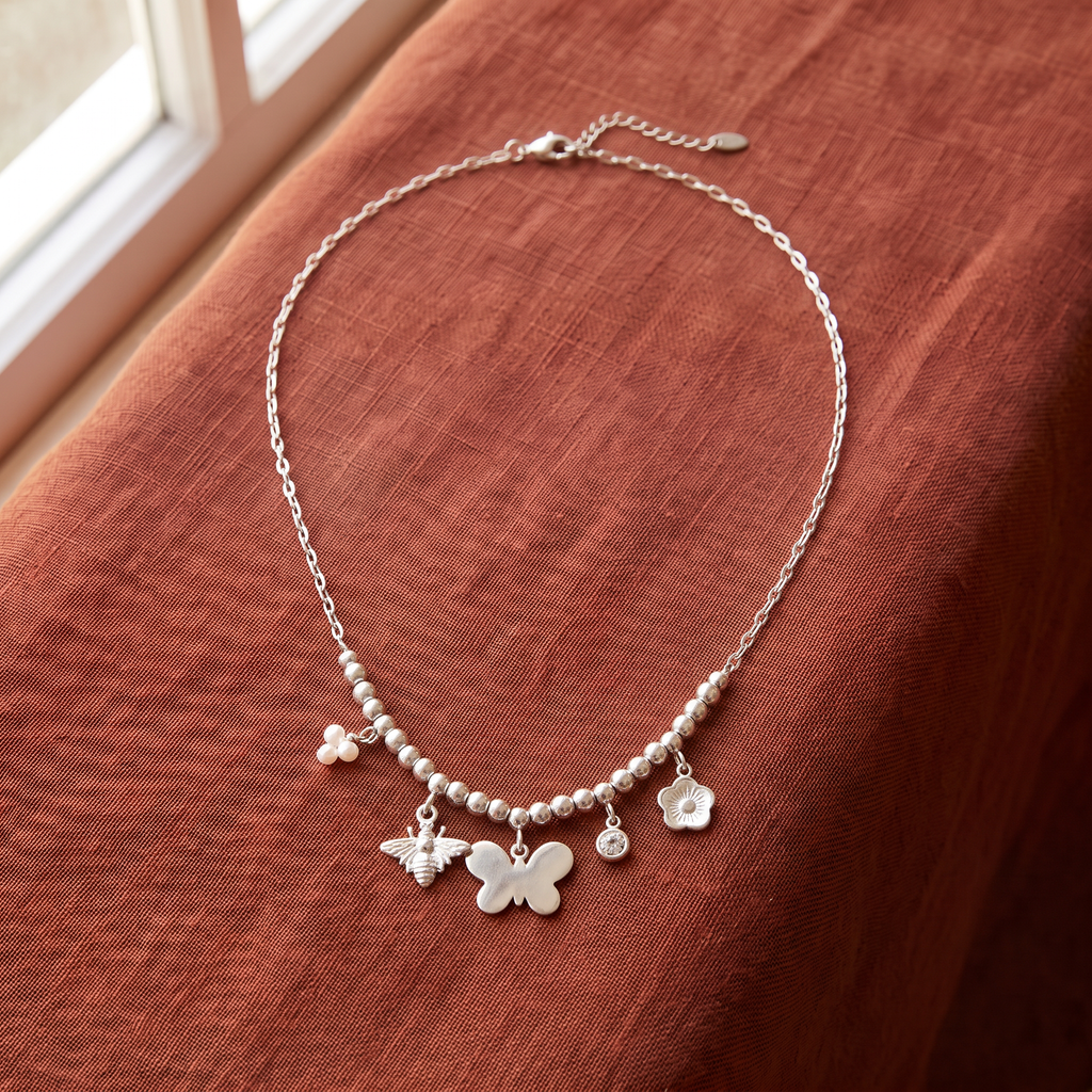 Collier charms fleur et papillon, porté en tenue, argenté