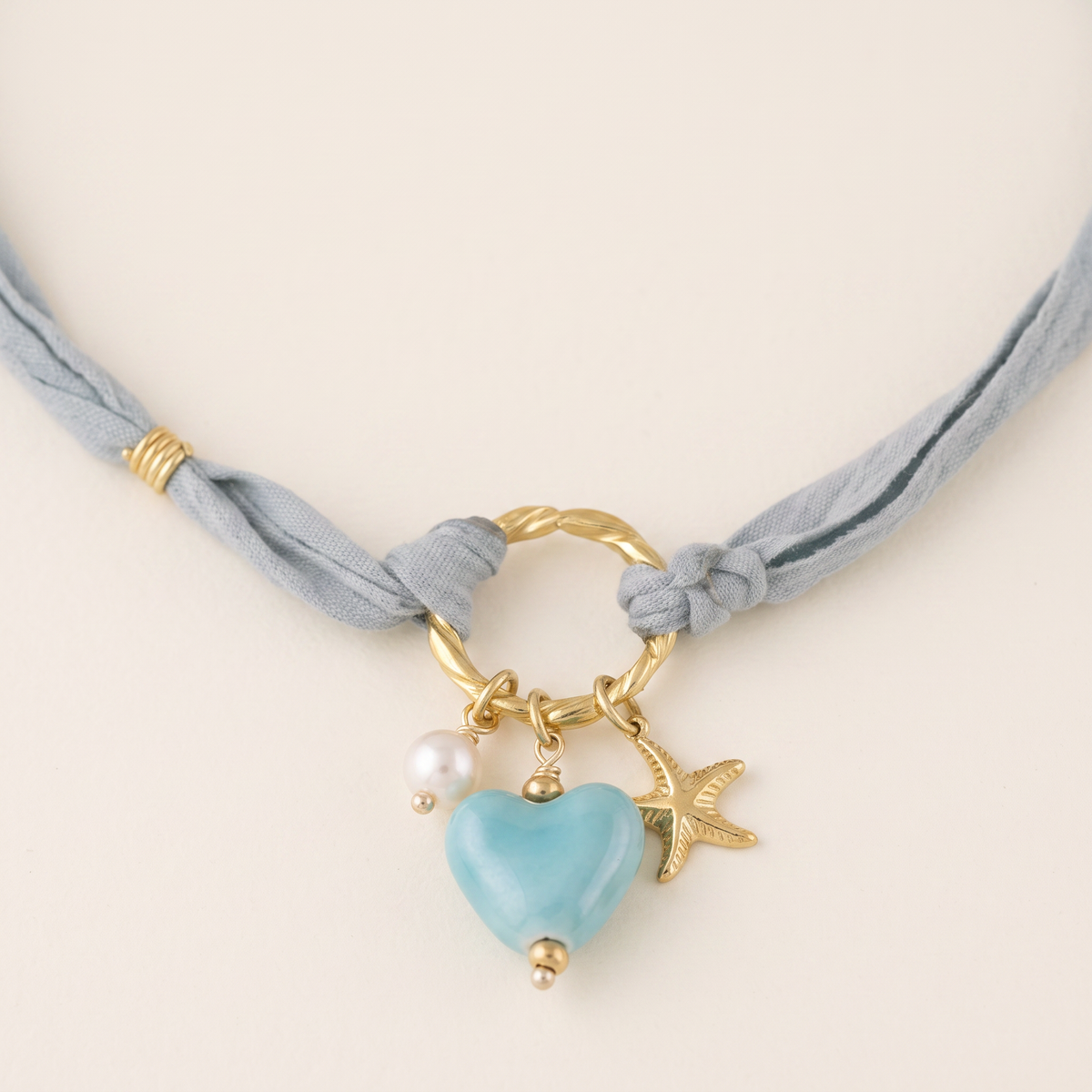 Collier cœur et étoile de mer bleu sur cordon foulard, détail du motif