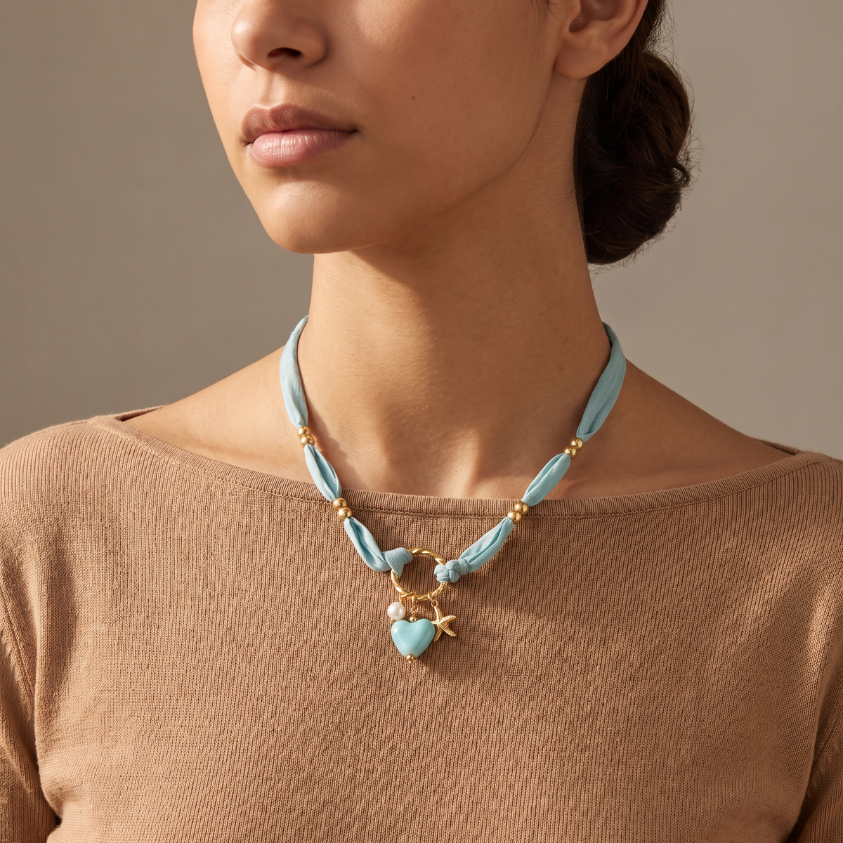 Collier cœur et étoile de mer bleu sur cordon foulard, porté mi-corps
