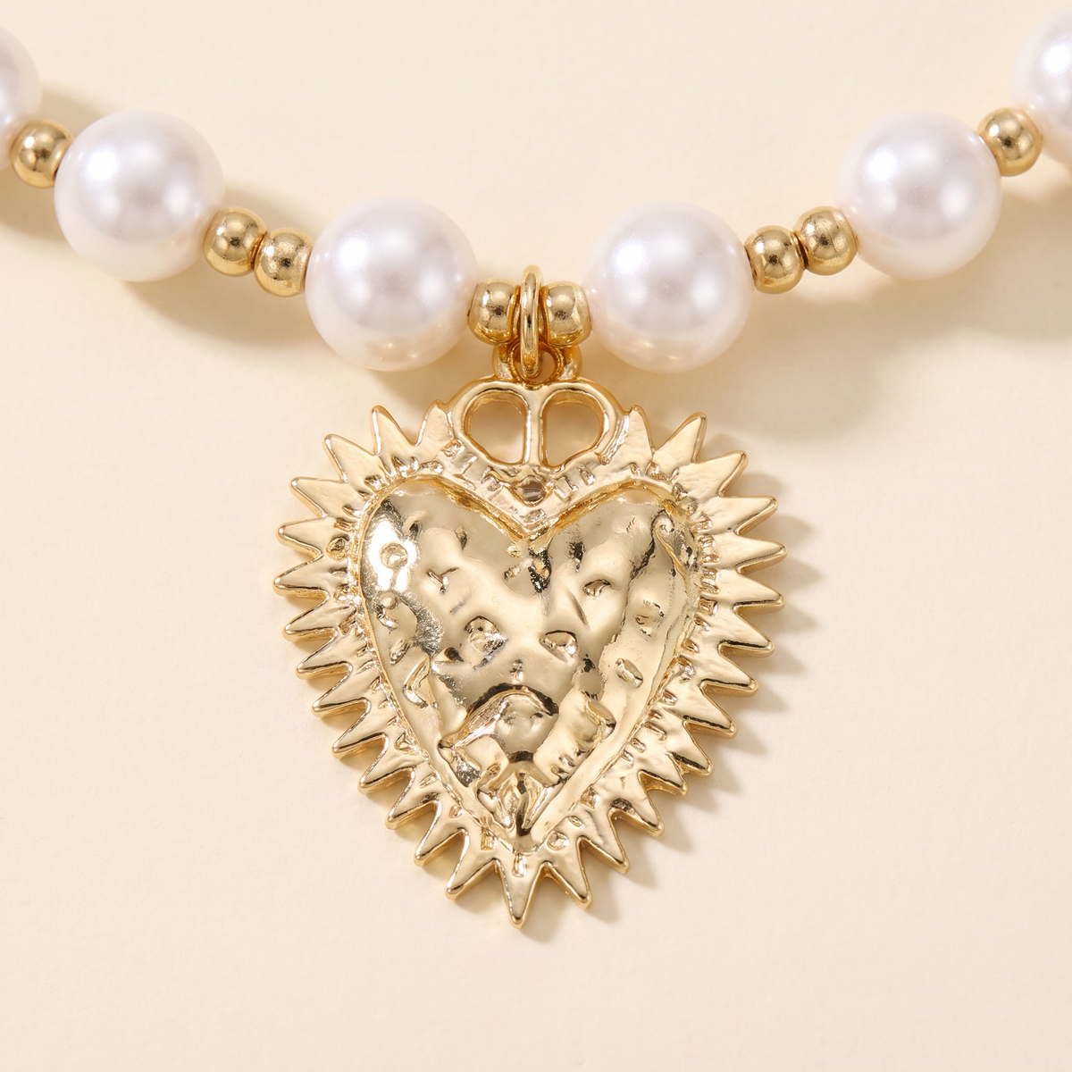 Collier cœur doré à breloques en perles, détail du motif